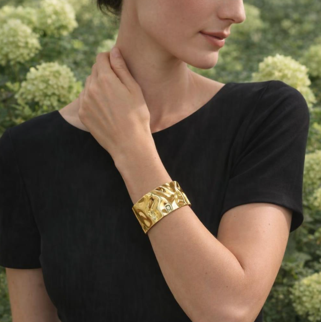 Brazalete de acero inoxidable ajustable. En color dorado.