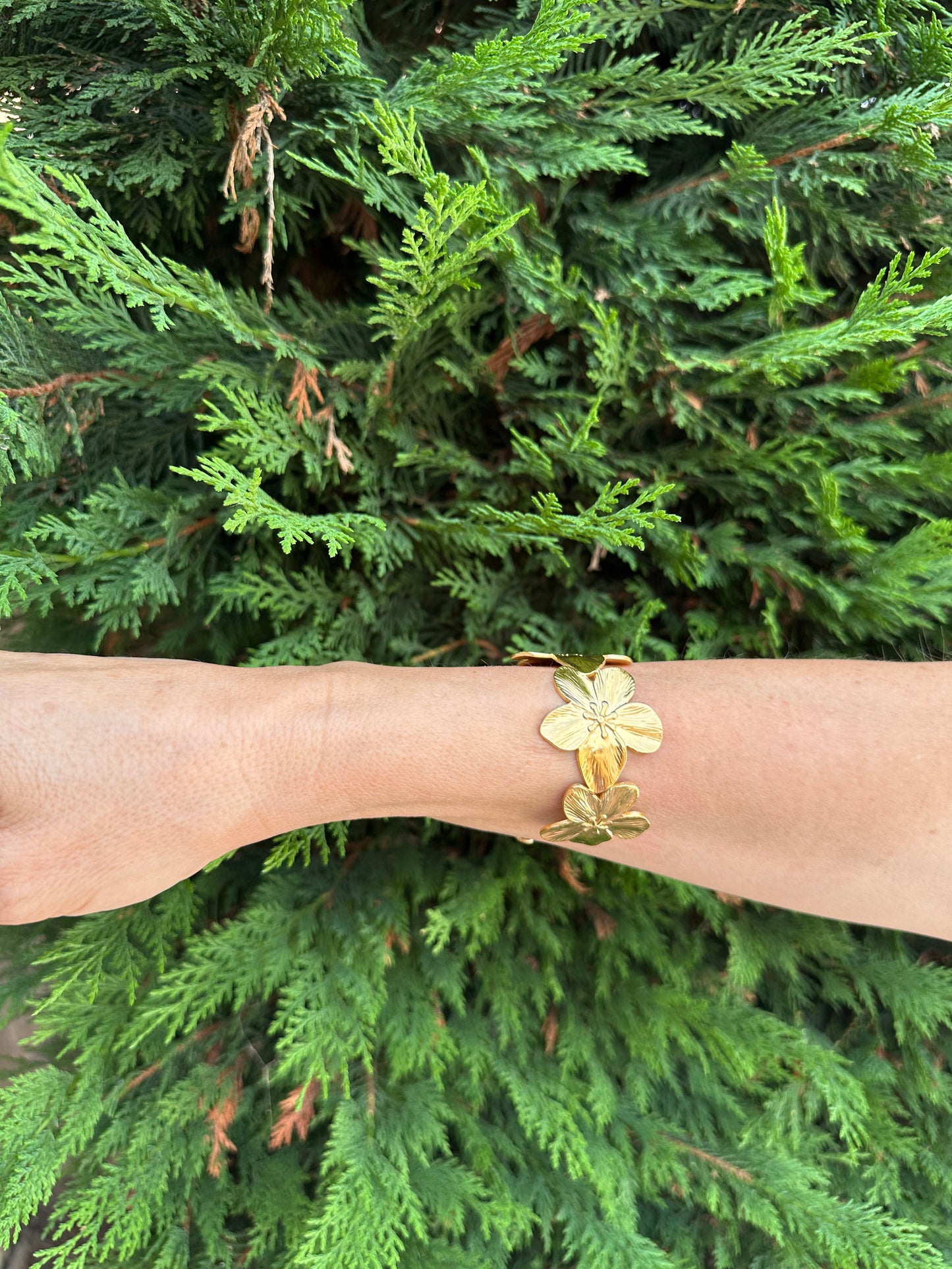 Brazalete de acero inoxidable ajustable. En color dorado. Diseño muy original con flores.