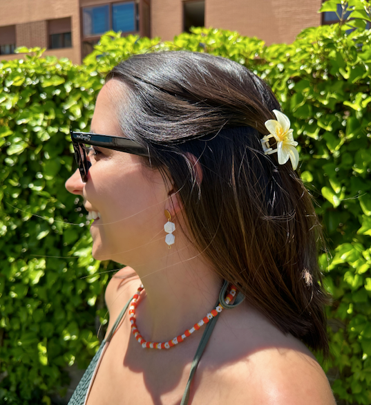 Collar hecho a mano con margaritas y cuentas de cerámica en tonos naranja y amarillo. Con cierre ajustable en acero inoxidable