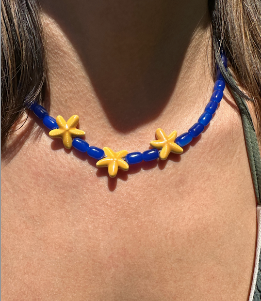 Collar hecho a mano con cuentas de cerámica en azul y tres estrellas de cerámica en amarillo en el centro. Con cierre ajustable en acero inoxidable