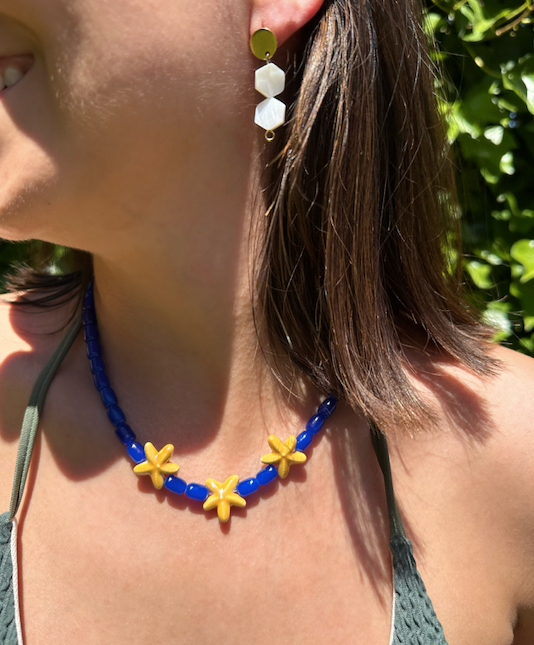 Collar hecho a mano con cuentas de cerámica en azul y tres estrellas de cerámica en amarillo en el centro. Con cierre ajustable en acero inoxidable
