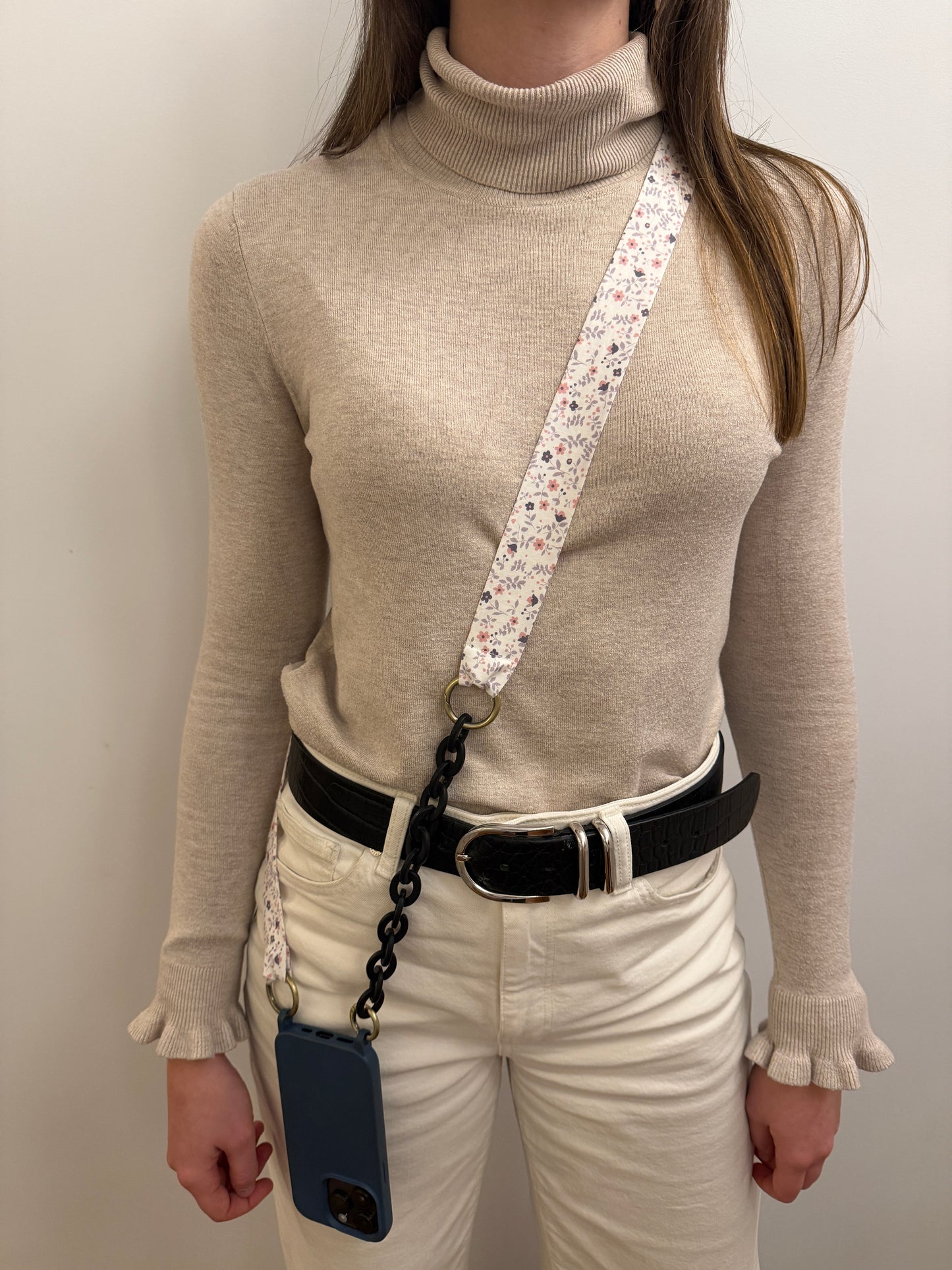 Cuelgamóvil con tela con flores y eslabones negros. Ajustable y con arandelas de acero inoxidable.