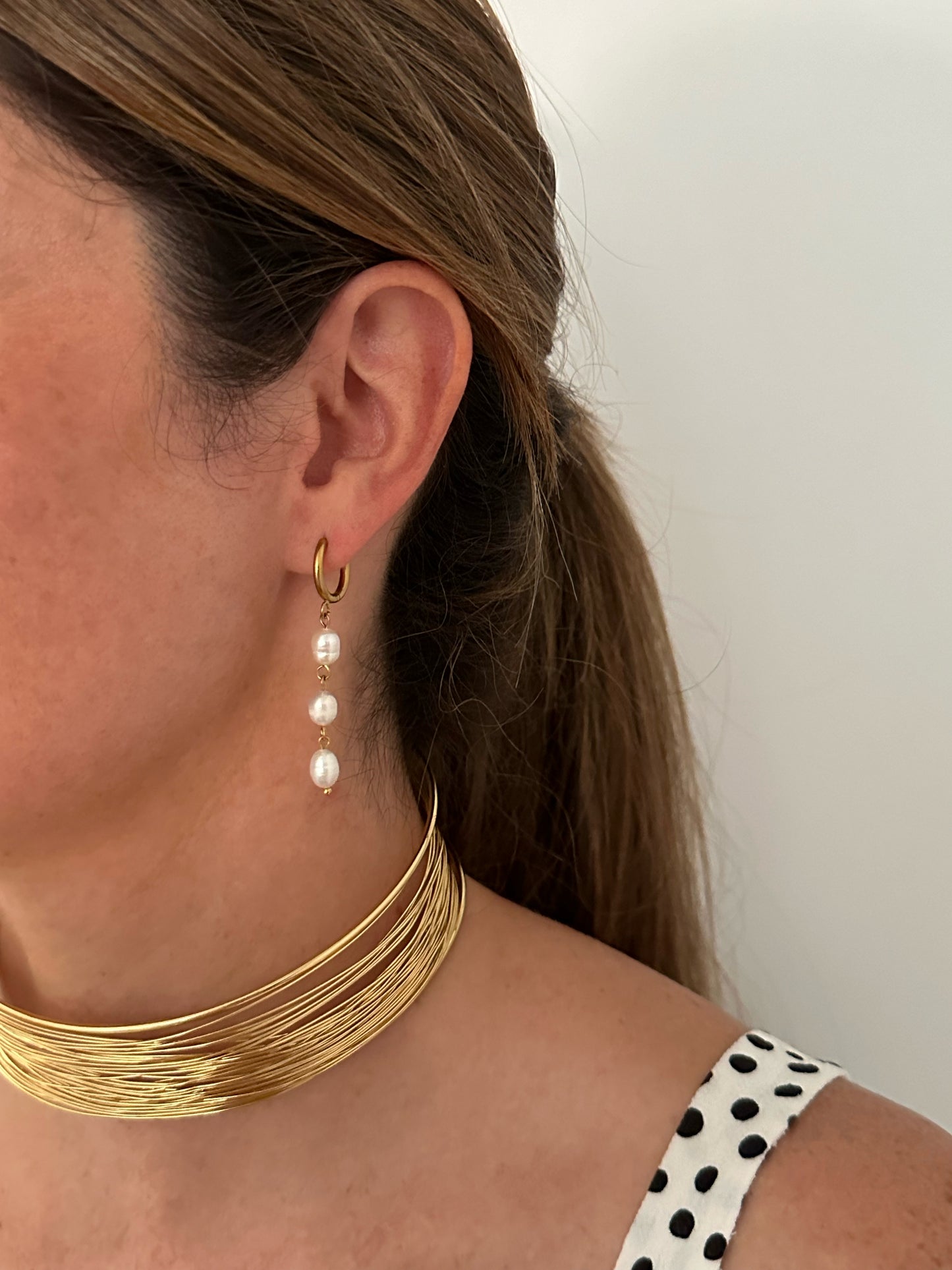 Pendientes para invitada de acero inoxidable. Con arito de acero inoxidable en color oro y tres perlas de río, estos pendientes son perfectos para elevar tus looks en eventos. Son hipoalergénicos