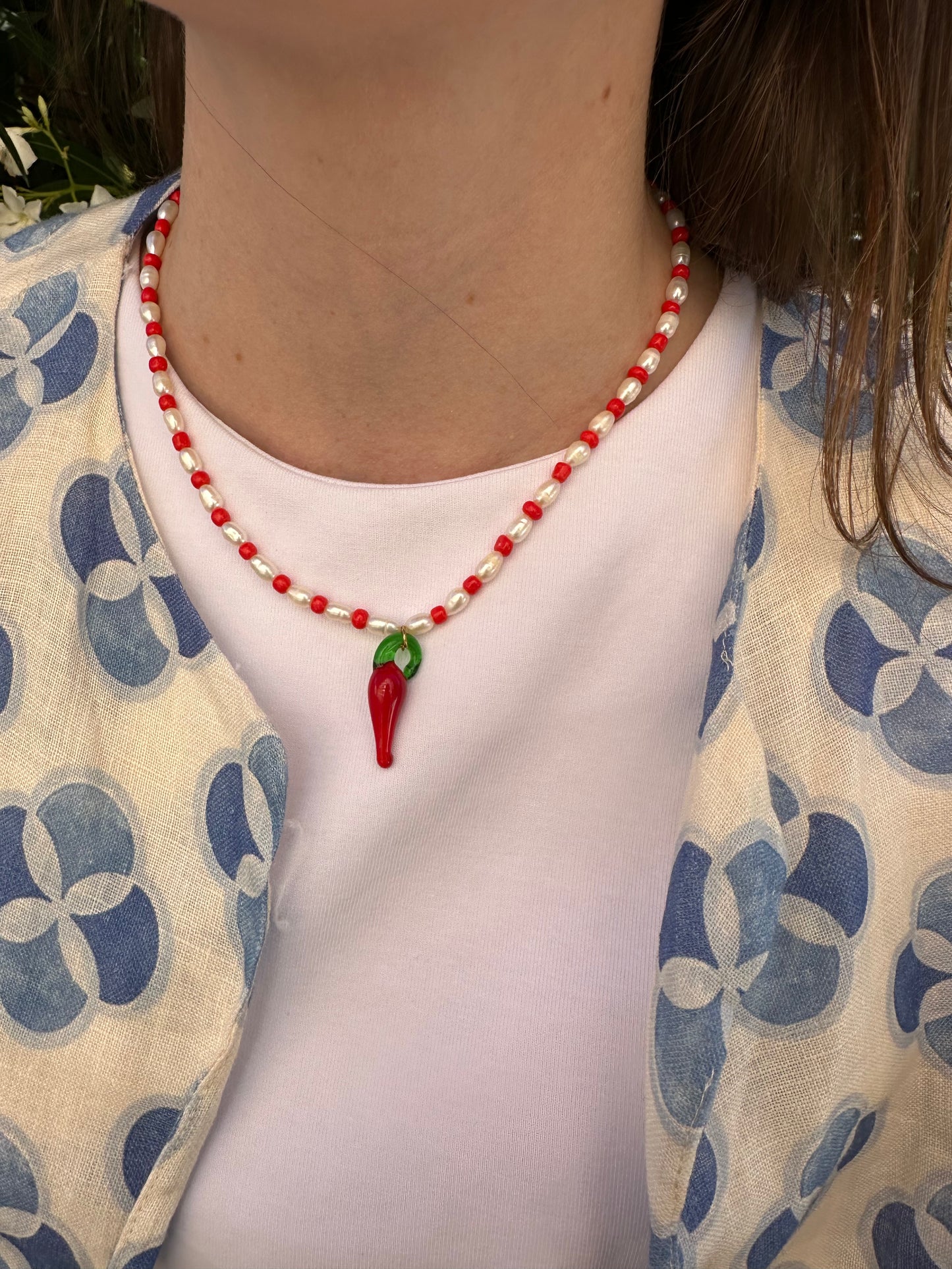 Collar hecho a mano con piedras de río y bolitas rojas, con un abalorio con forma de chili de cristal de murano en color rojo y verde