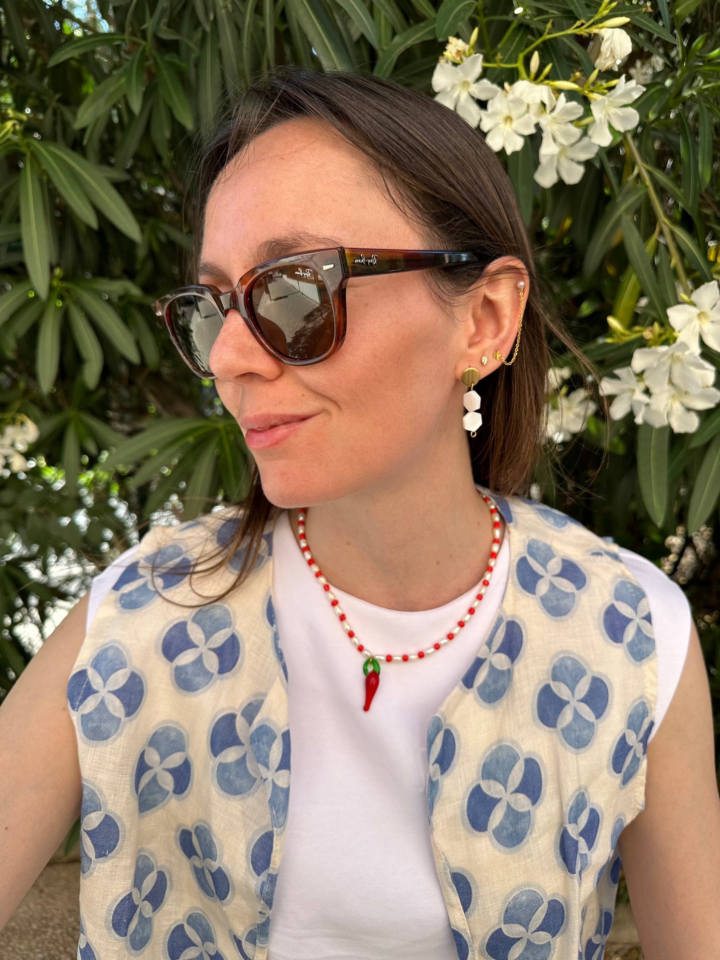 Collar hecho a mano con piedras de río y bolitas rojas, con un abalorio con forma de chili de cristal de murano en color rojo y verde