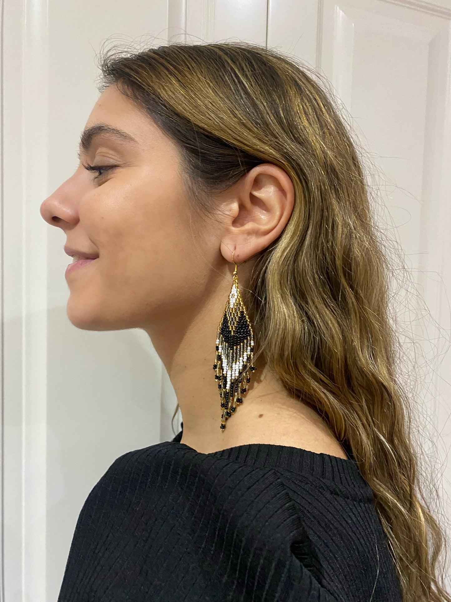 Pendientes de bolitas en tonos negros y dorados, hechos con técnica miyuki con una caída preciosa. Cierre de acero inoxidable.