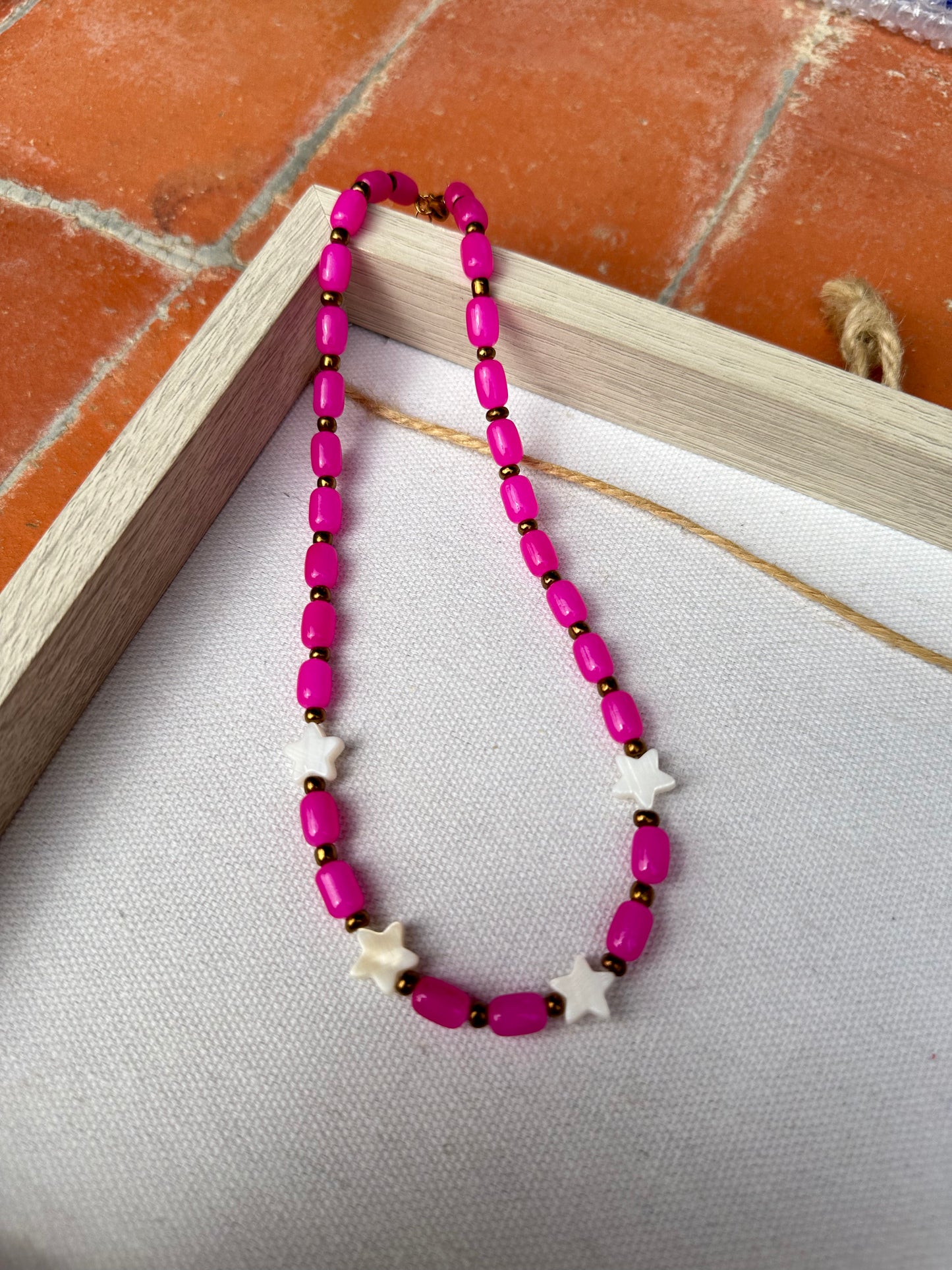 Collar hecho a mano con cuentas de cerámica rosas, cuentas doradas y con 4 estrellas de nácar. Cierre ajustable de acero inoxidable