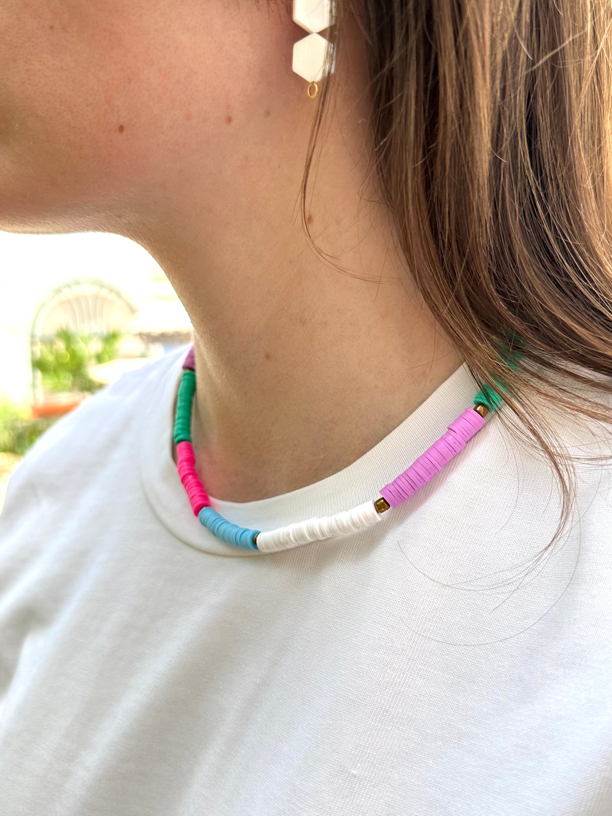 Collar hecho a mano con arcilla polimérica en varios colores fosforitos: rosa, azul, verde, lila y blanco, separados por cuentas espaciadoras doradas. Con cierre ajustable en acero inoxidable