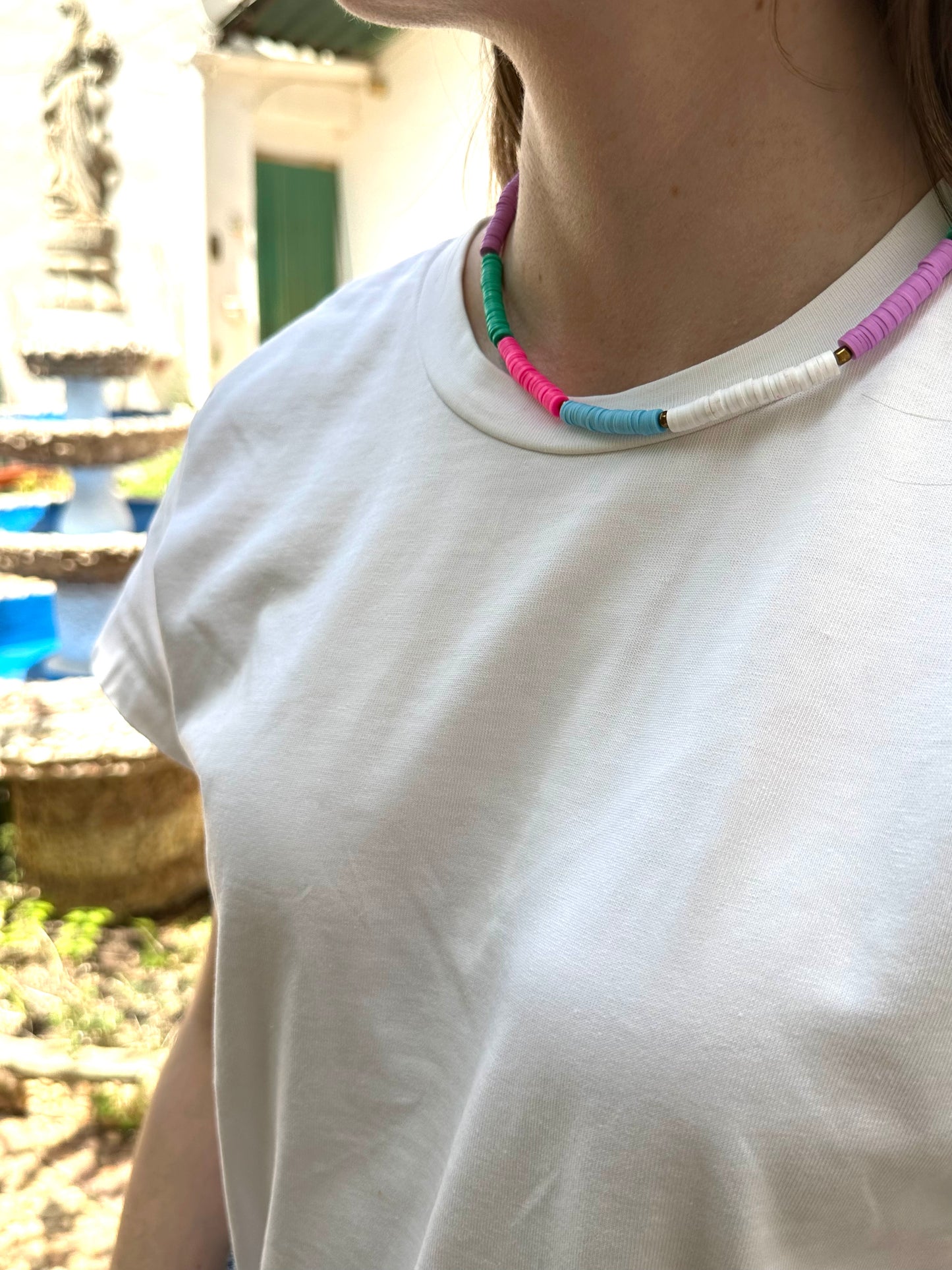 Collar hecho a mano con arcilla polimérica en varios colores fosforitos: rosa, azul, verde, lila y blanco, separados por cuentas espaciadoras doradas. Con cierre ajustable en acero inoxidable