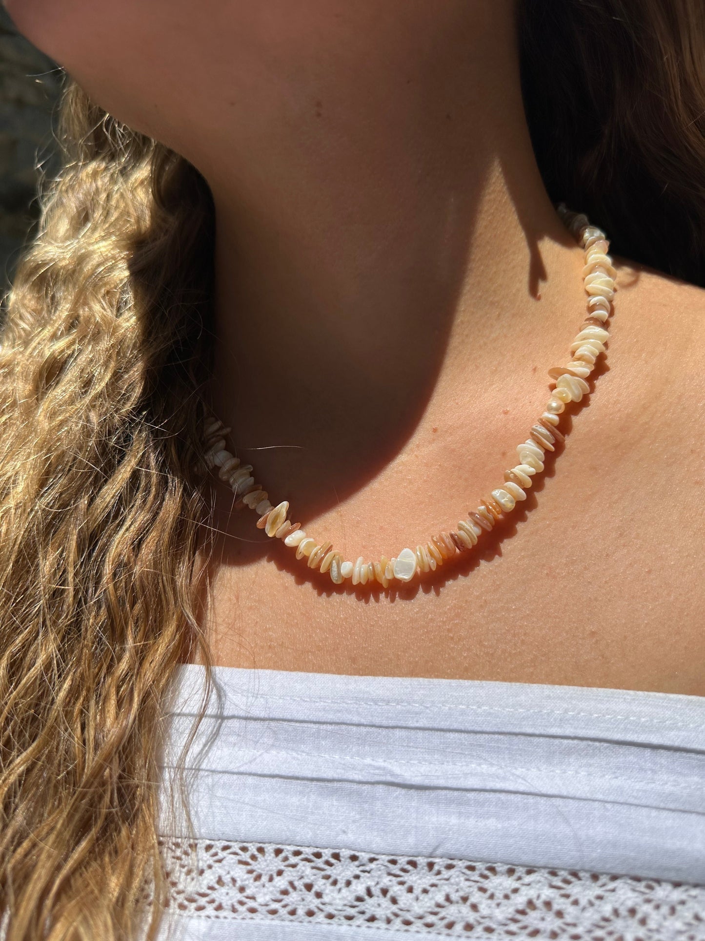 Collar hecho a mano con piedras naturales de color blanco. Cierre y alargadera de acero inoxidable.