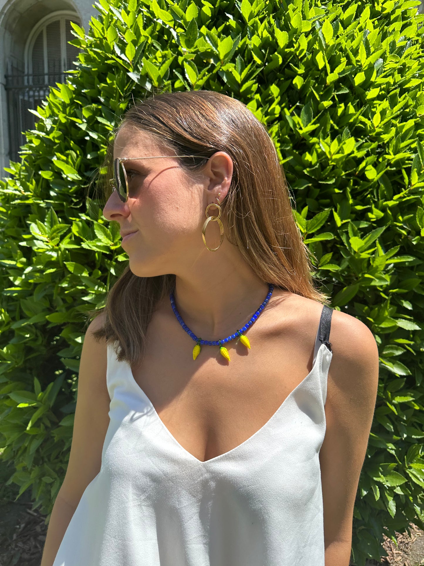 Collar hecho a mano con cuentas de cerámica azul y con tres abalorios con forma de mazorcas de maíz de cristal de murano en color amarillo. Cierre ajustable de acero inoxidable