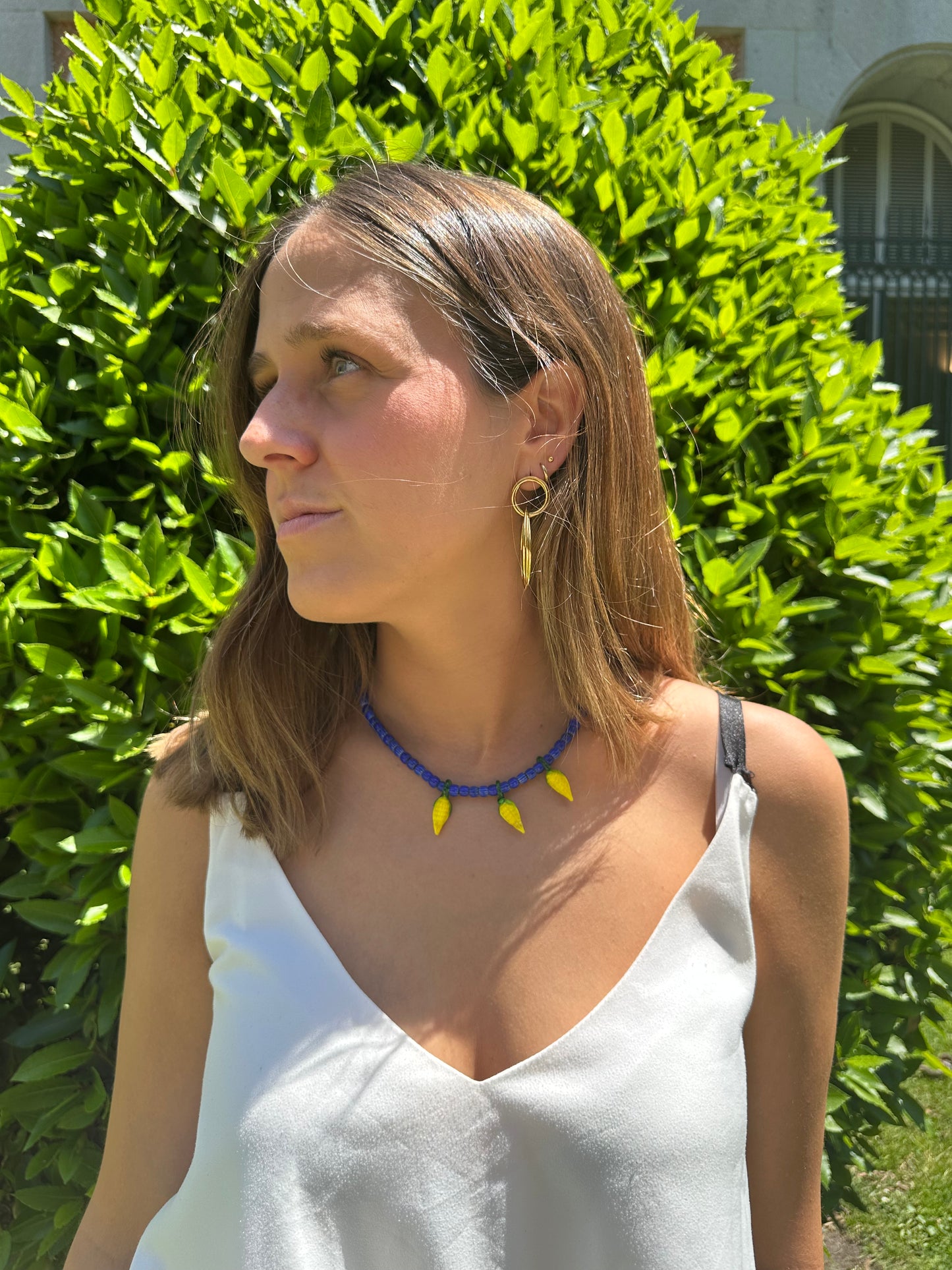 Collar hecho a mano con cuentas de cerámica azul y con tres abalorios con forma de mazorcas de maíz de cristal de murano en color amarillo. Cierre ajustable de acero inoxidable