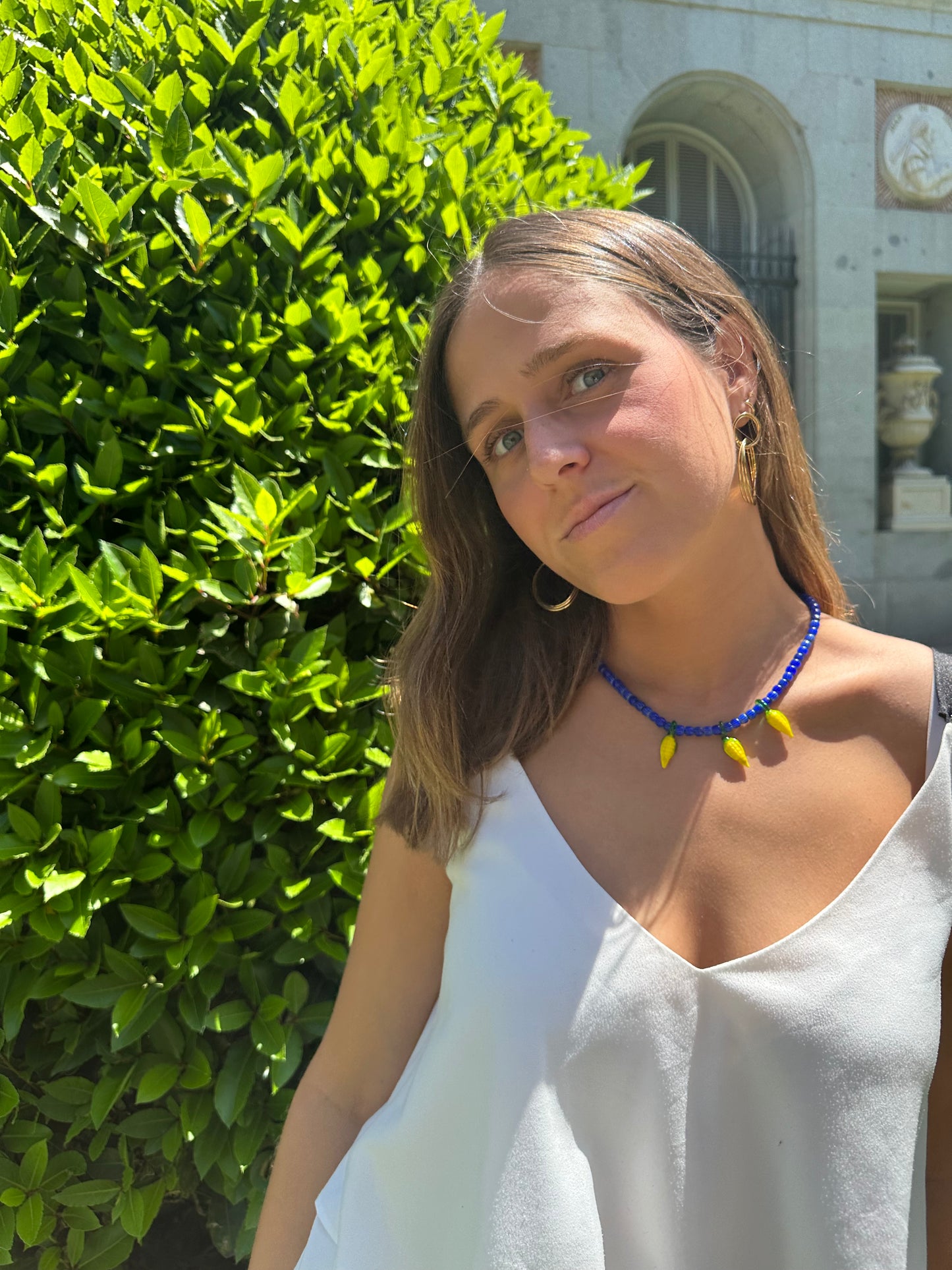 Collar hecho a mano con cuentas de cerámica azul y con tres abalorios con forma de mazorcas de maíz de cristal de murano en color amarillo. Cierre ajustable de acero inoxidable