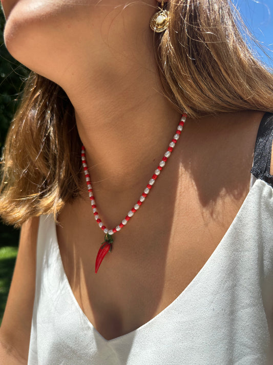 Collar hecho a mano con piedras de río y bolitas rojas, con un abalorio con forma de chili de cristal de murano en color rojo y verde