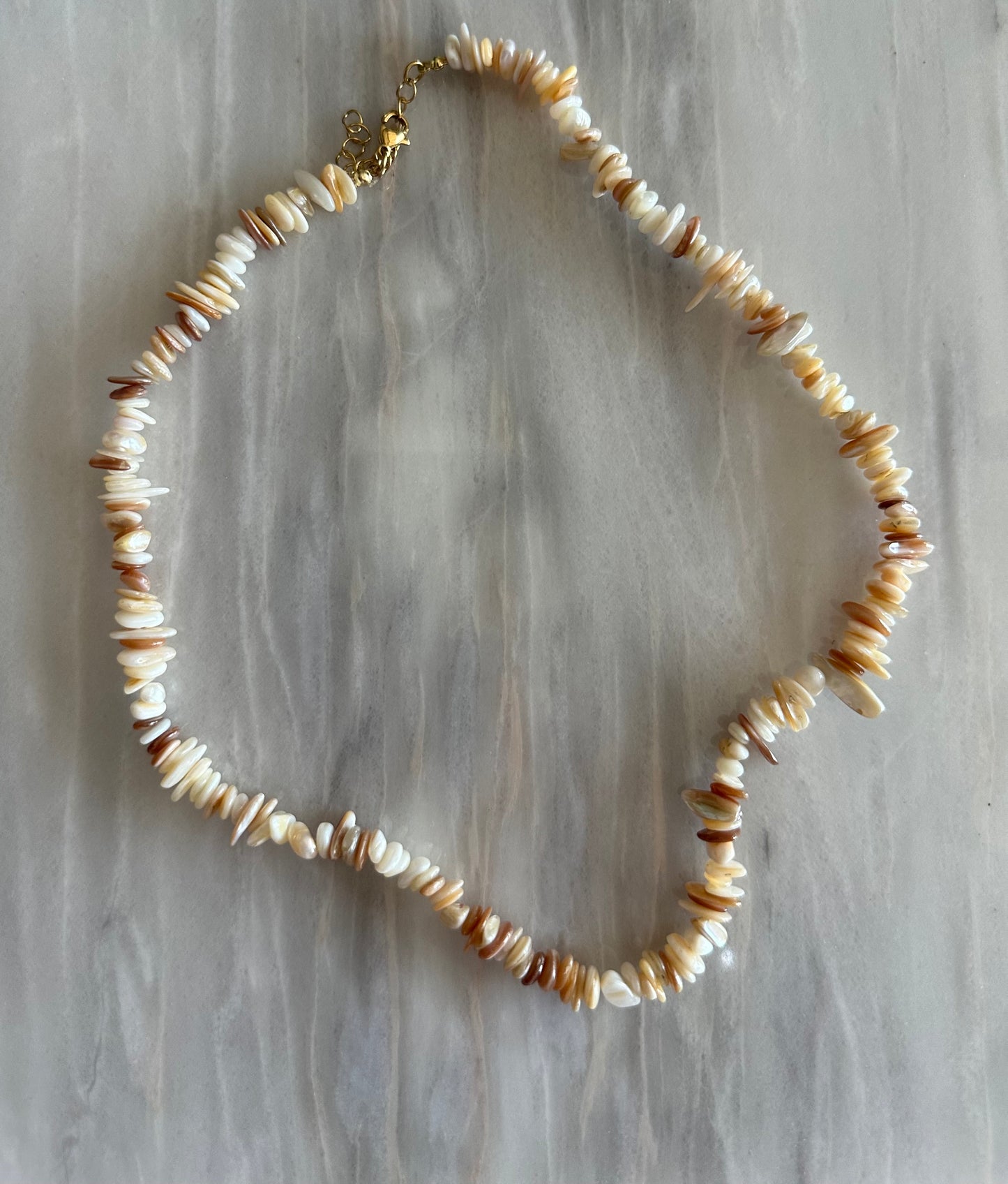 Collar hecho a mano con piedras naturales de color blanco. Cierre y alargadera de acero inoxidable.