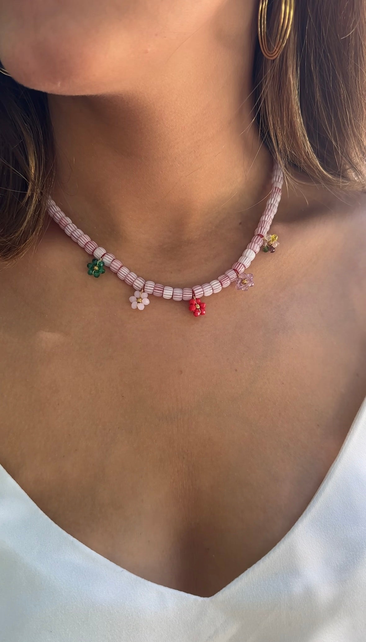 Collar hecho a mano con cuentas de cerámica blancas y bolitas formando florecitas. Cierre ajustable