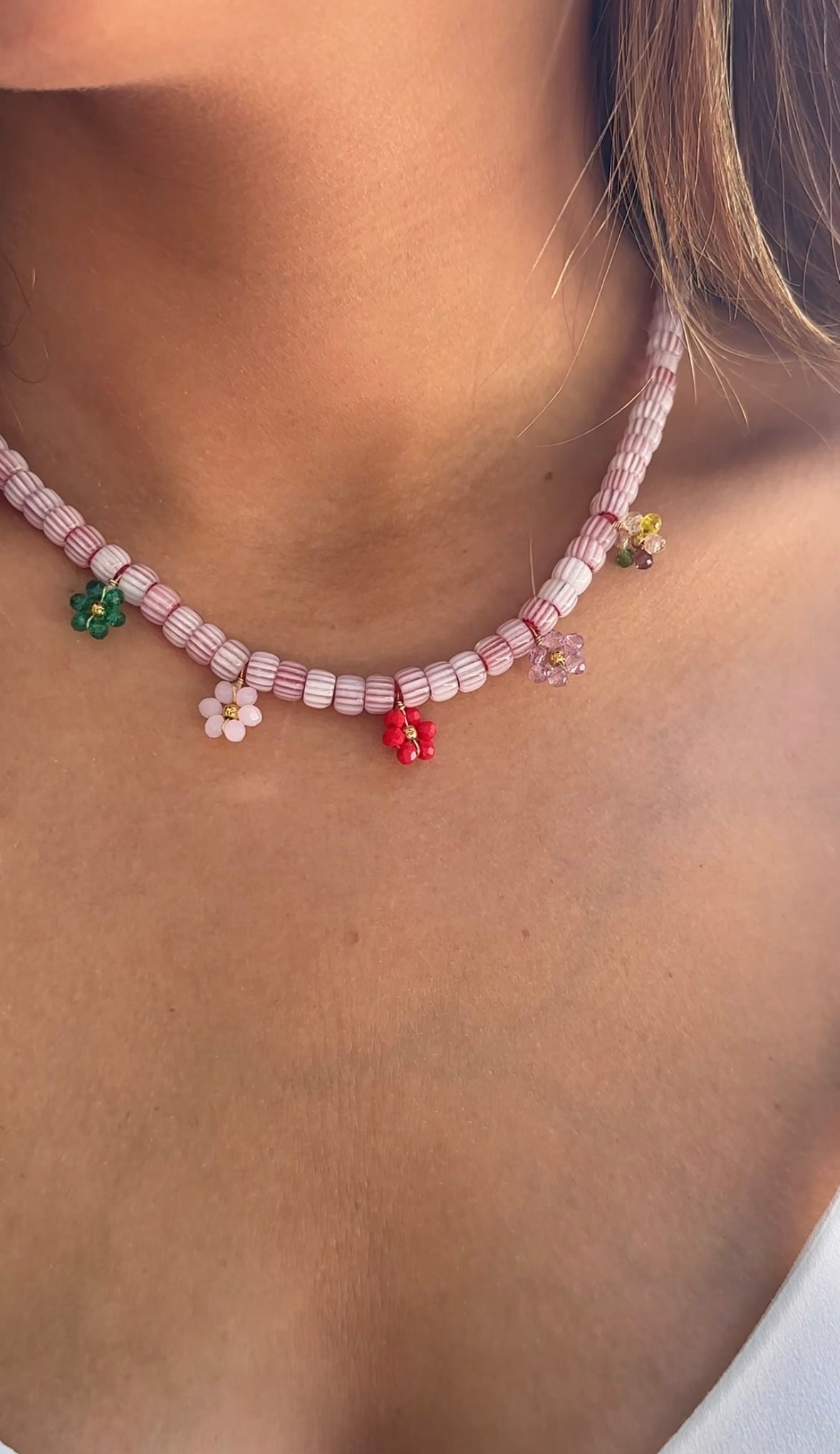 Collar hecho a mano con cuentas de cerámica blancas y bolitas formando florecitas. Cierre ajustable