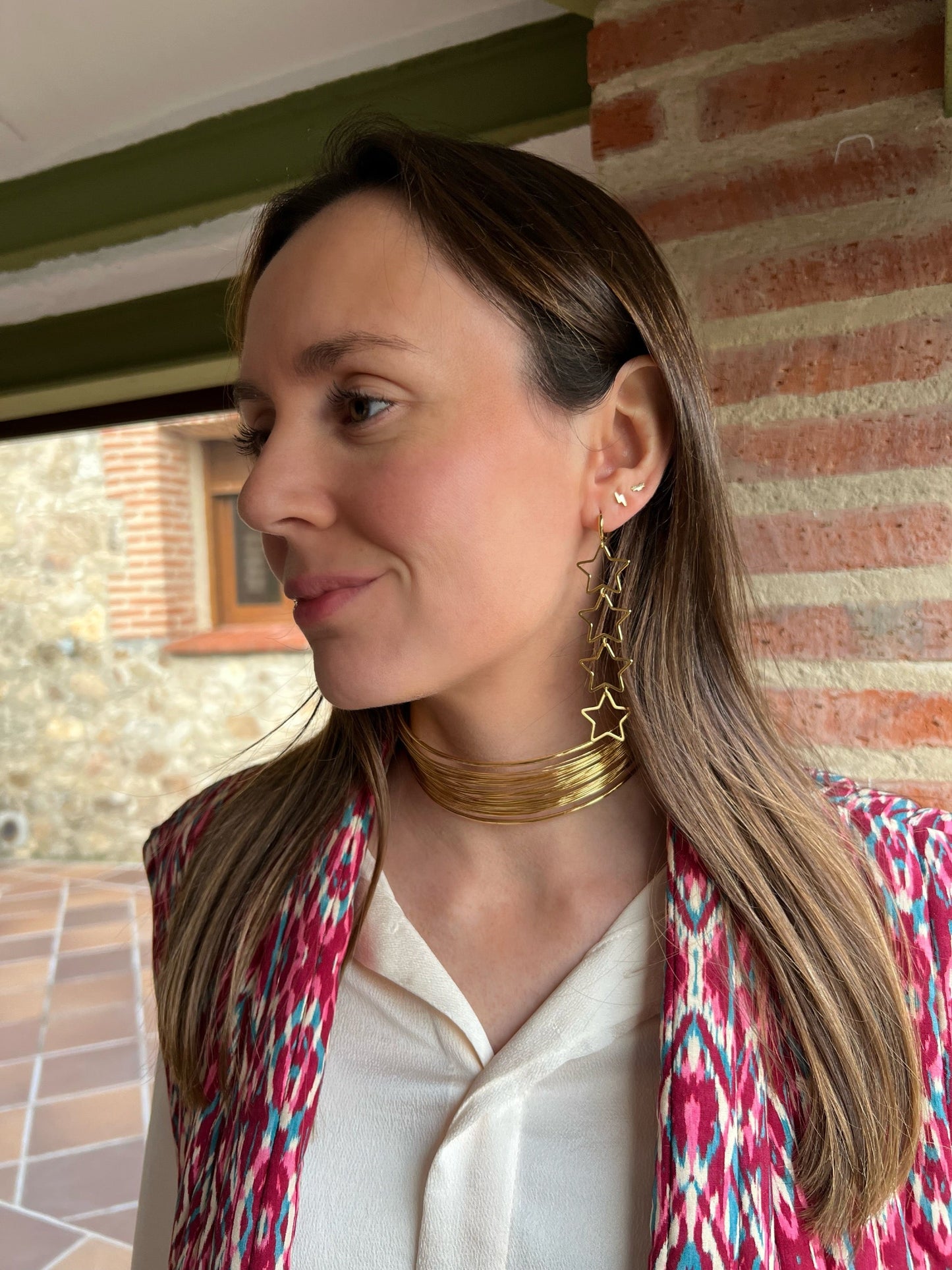 Pendientes aro con cuatro estrellas colgantes de color oro. Son de acero inoxidable e hipoalergénicos.