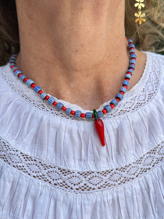 Collar hecho a mano con cuentas de cerámica azul y bolitas rojas, con un abalorio con forma de chili de cristal de murano en color rojo y verde. Cierre ajustable