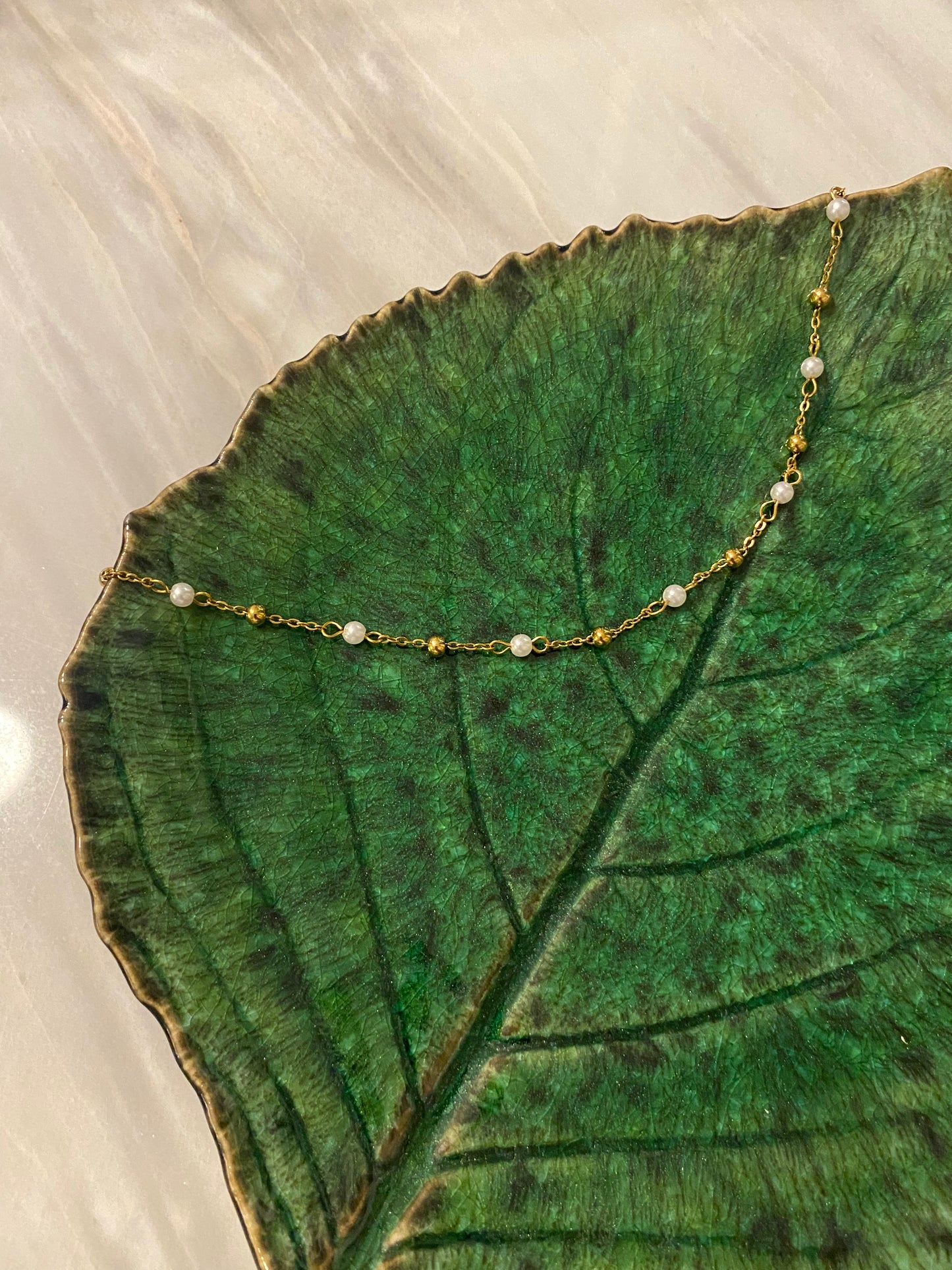 Collar de acero inoxidable en color oro con perla de río. Es ajustable e hipoalergénico.