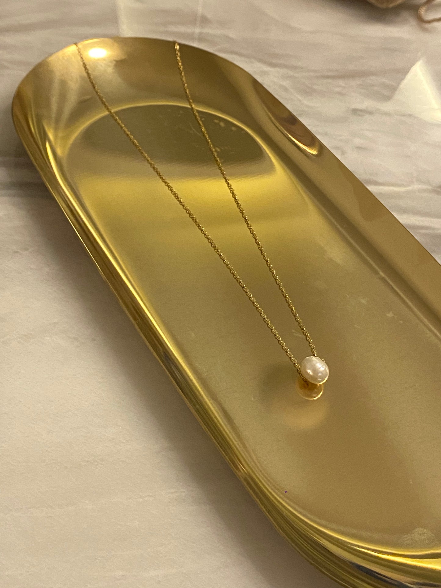Collar de acero inoxidable en color oro con perla de río. Es ajustable e hipoalergénico.
