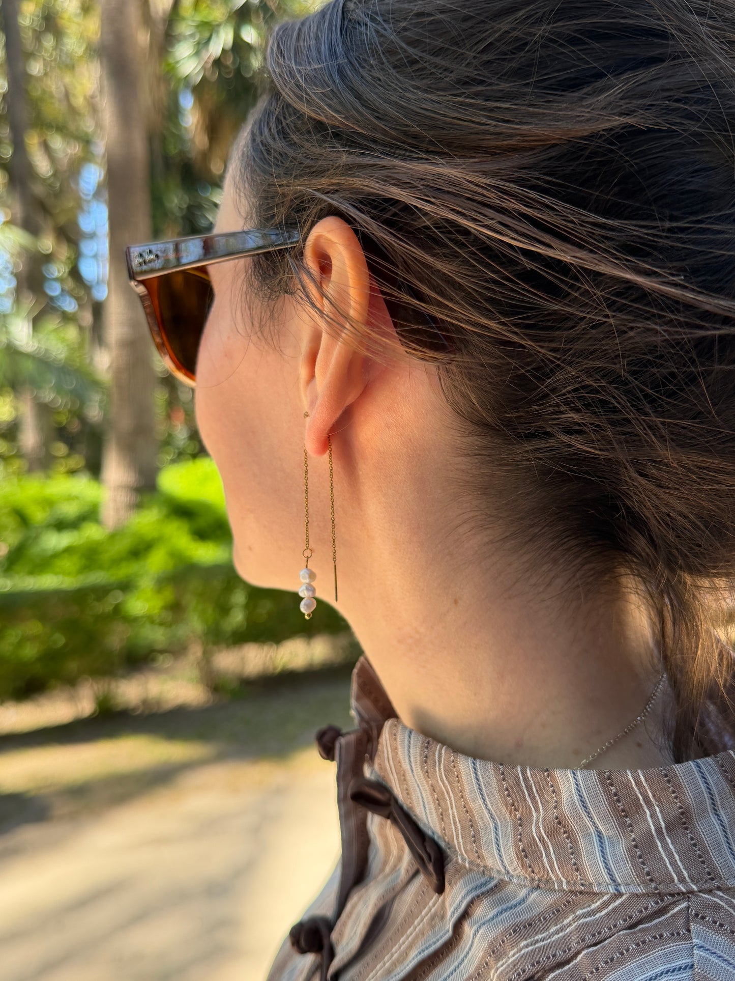 Pendientes dobles de acero inoxidable en color dorado largos con tres perlas. Estos pendientes son perfectos para elevar tus looks.
