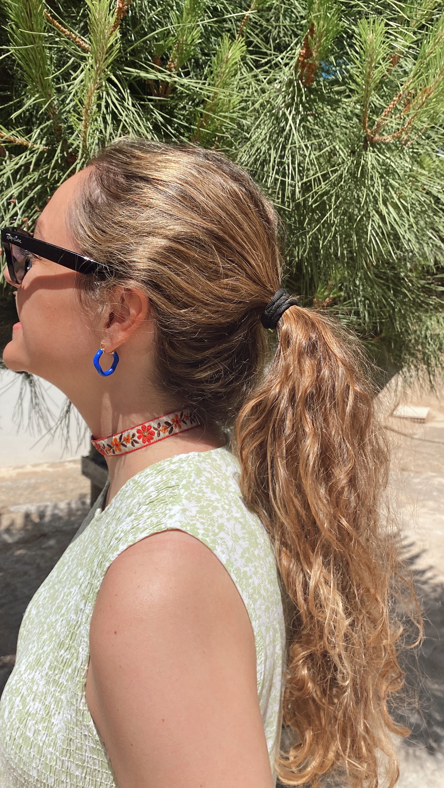 Modelo con choker de tela con flores bordadas, cierre ajustable y de acero inoxidable.