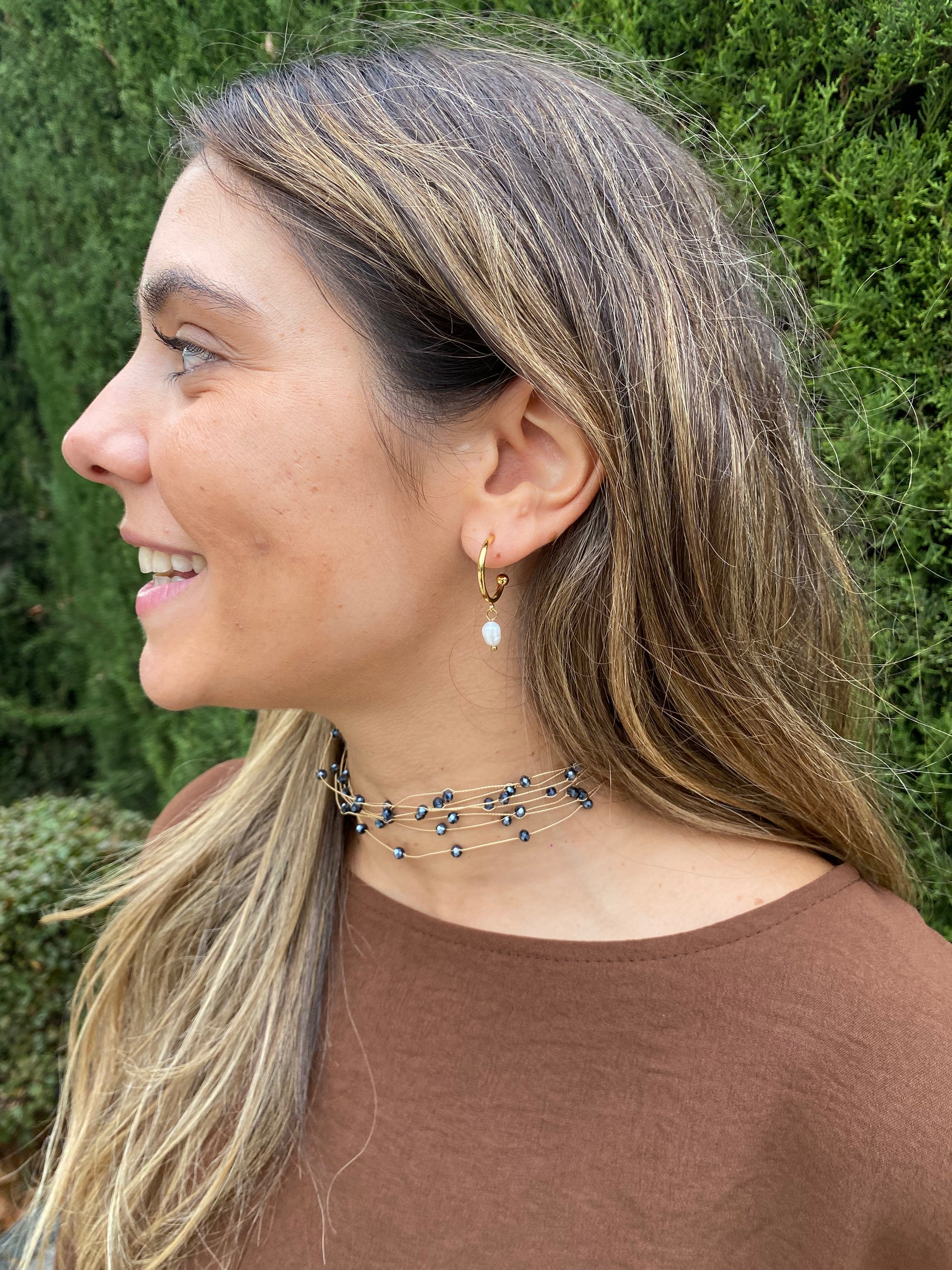 Pendientes de aro de acero inoxidable en color dorado con perla de río colgando. Estos pendientes son perfectos para elevar tus looks. 