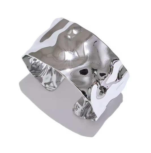 Brazalete de acero inoxidable ajustable. En color plateado.