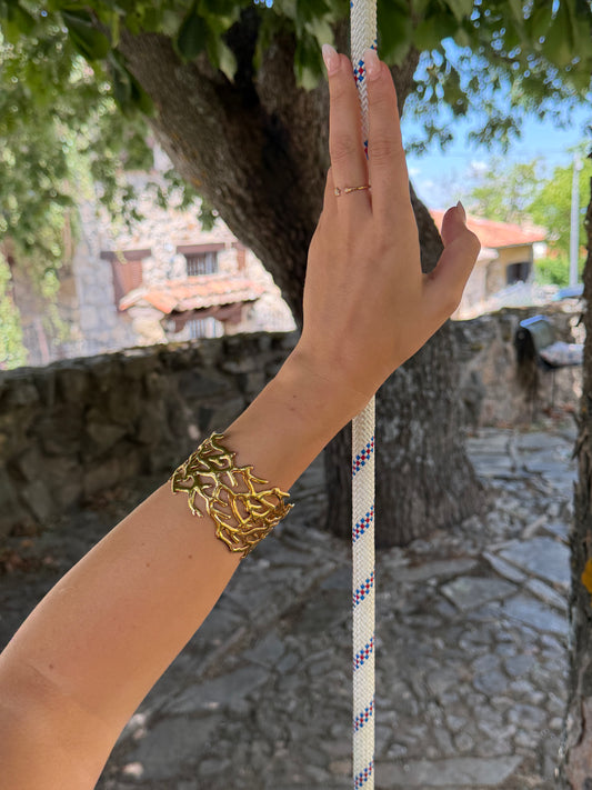 Brazalete de acero inoxidable ajustable. En color dorado.