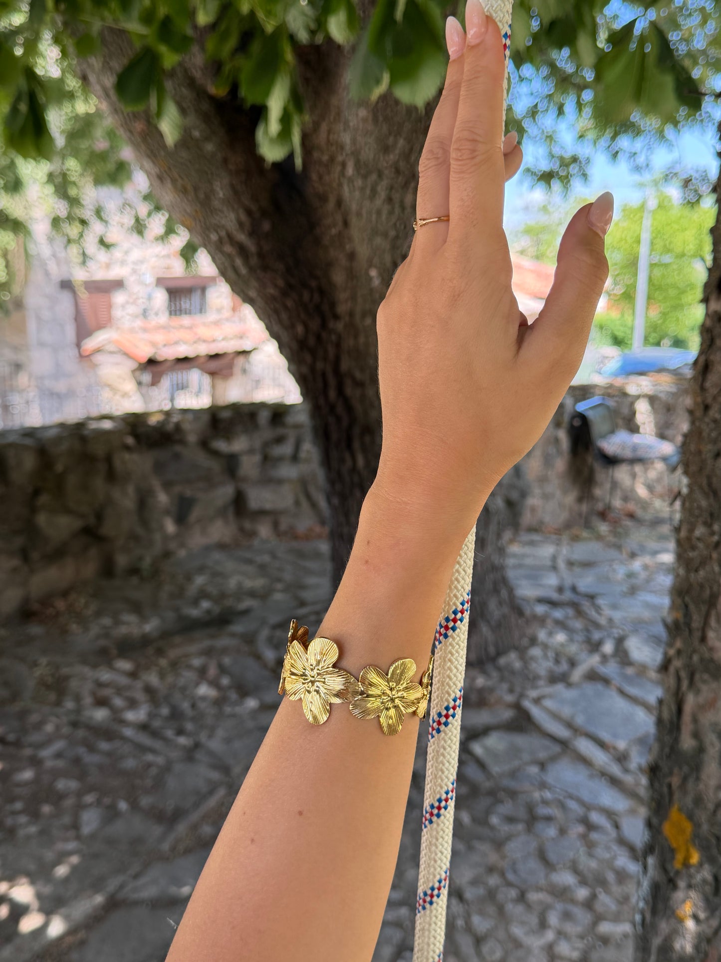 Brazalete de acero inoxidable ajustable. En color dorado. Diseño muy original con flores.