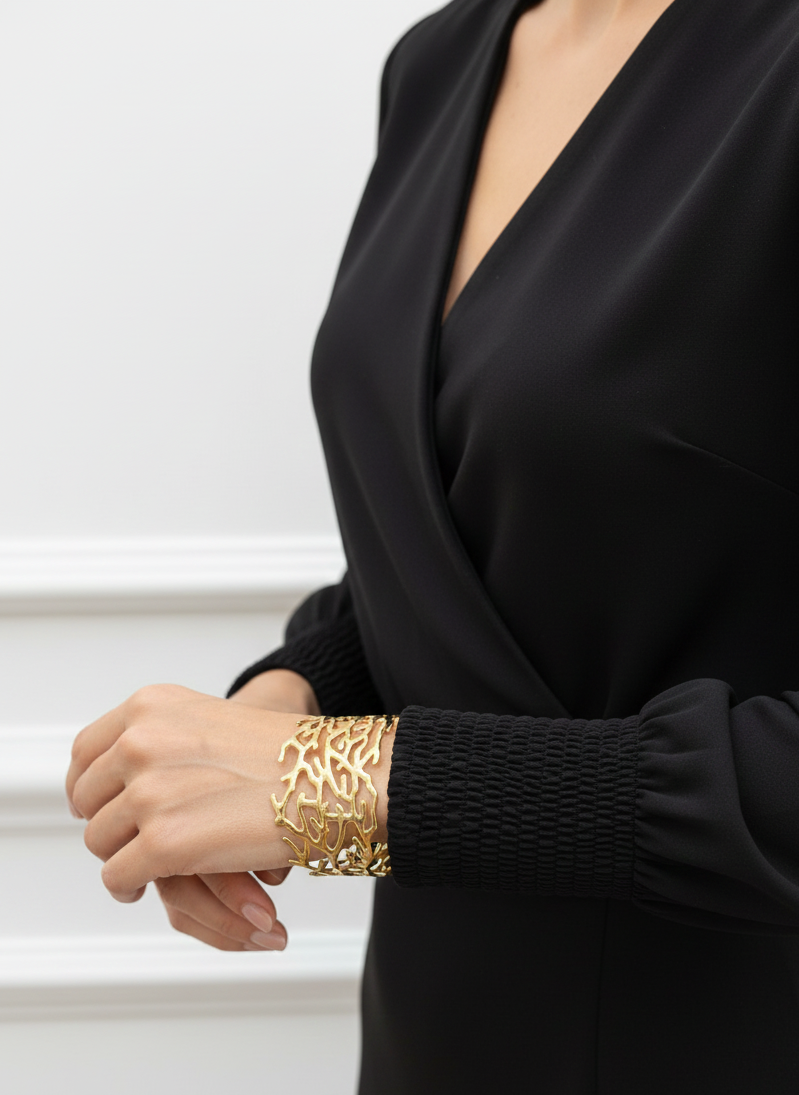 Brazalete de acero inoxidable ajustable. En color dorado.