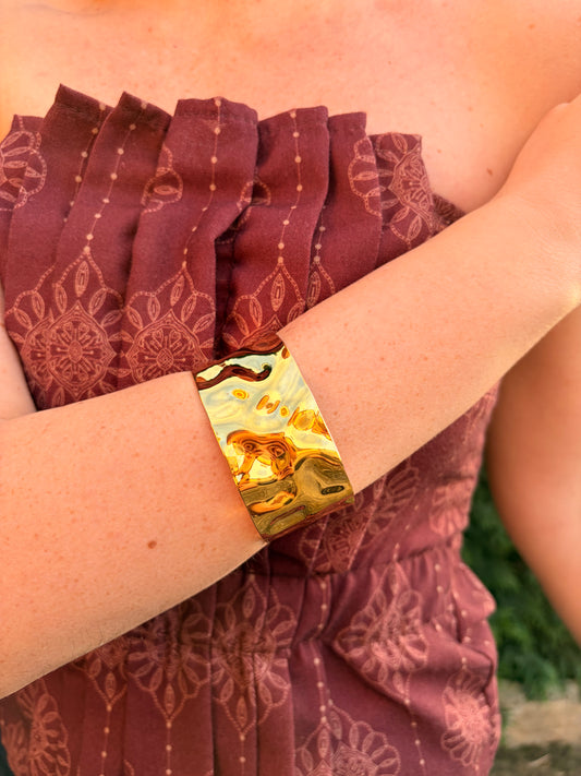 Brazalete de acero inoxidable ajustable. En color dorado.
