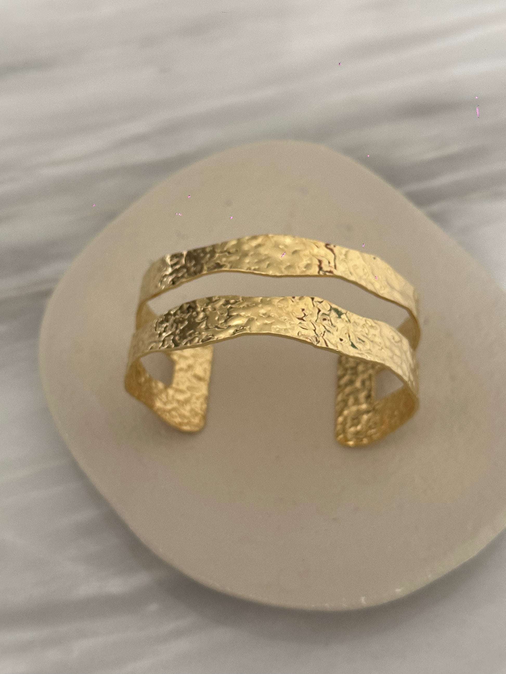 Brazalete de acero inoxidable ajustable. En color dorado. Diseño muy original.