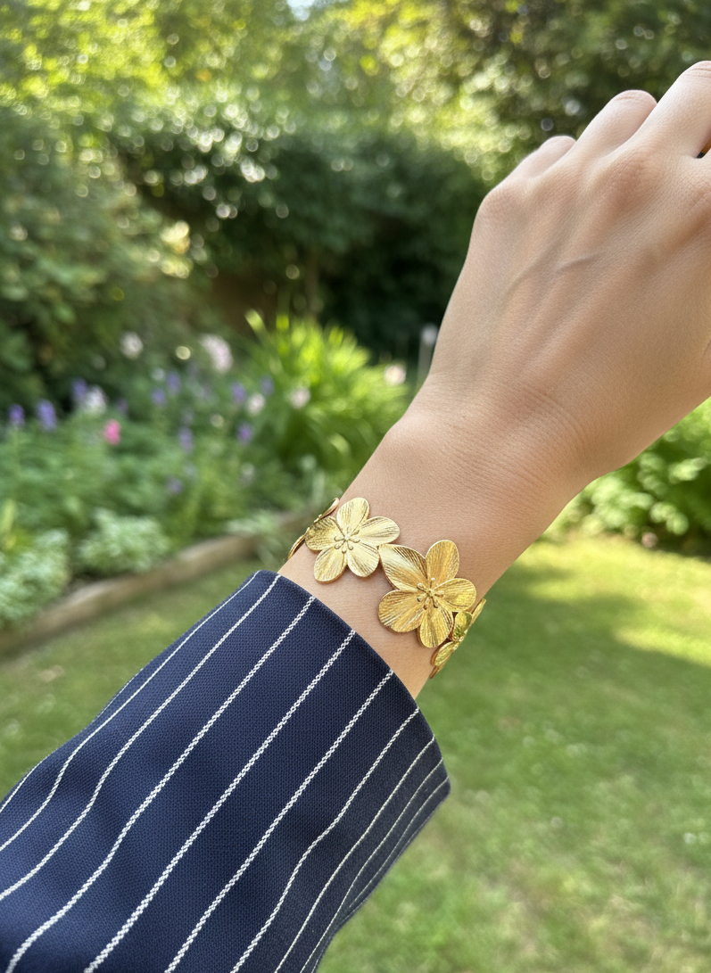 Brazalete de acero inoxidable ajustable. En color dorado. Diseño muy original con flores.