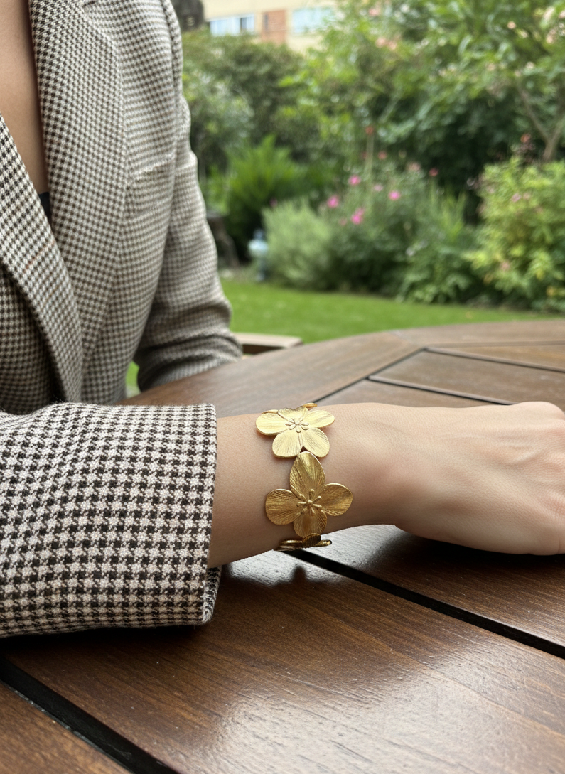 Brazalete de acero inoxidable ajustable. En color dorado. Diseño muy original con flores.