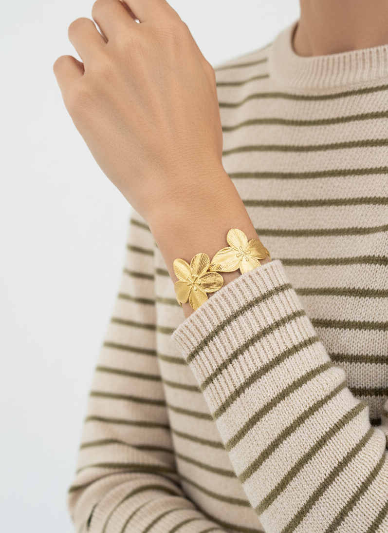 Brazalete de acero inoxidable ajustable. En color dorado. Diseño muy original con flores.