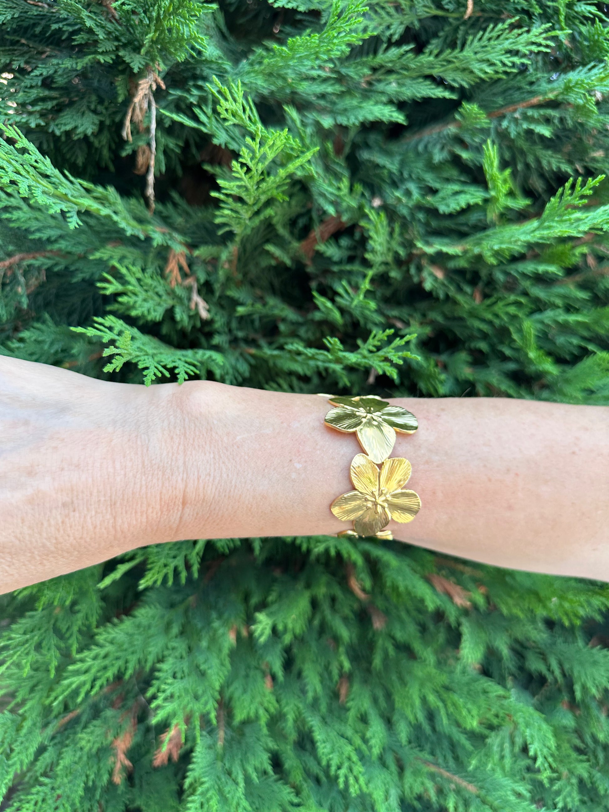 Brazalete de acero inoxidable ajustable. En color dorado. Diseño muy original con flores.