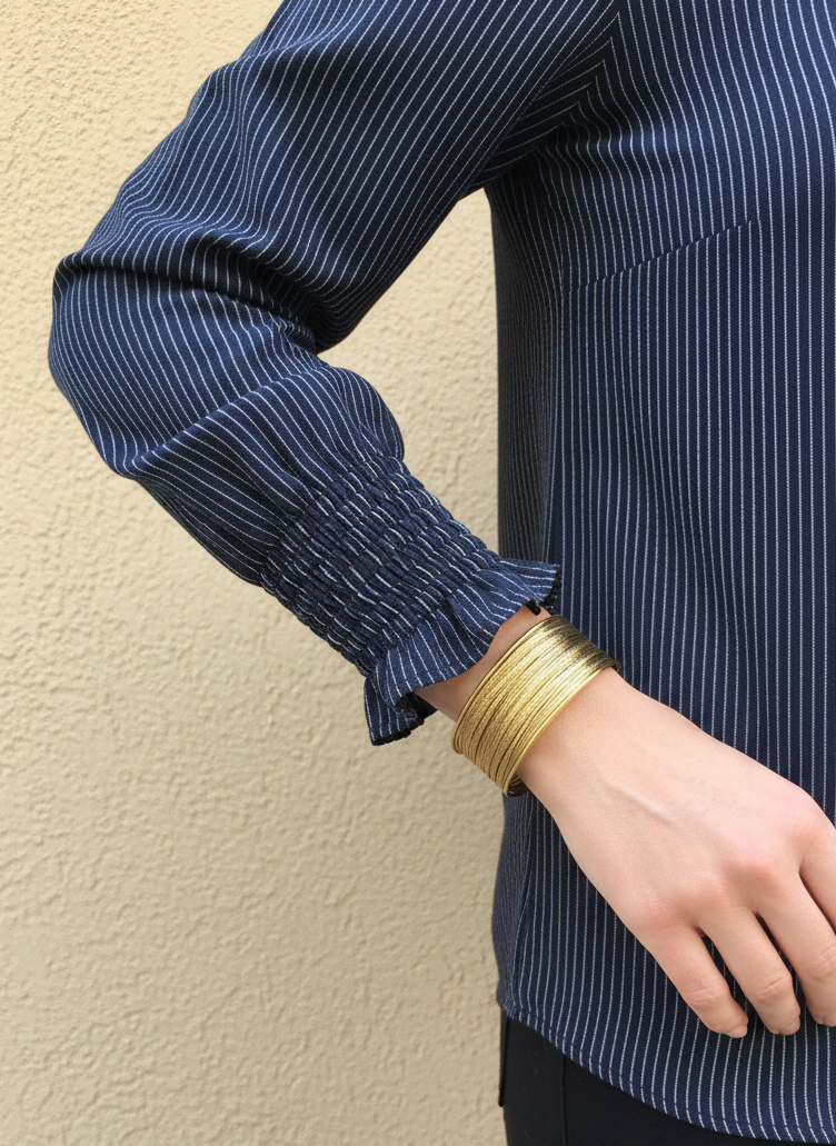 Brazalete de acero inoxidable ajustable. En color dorado.