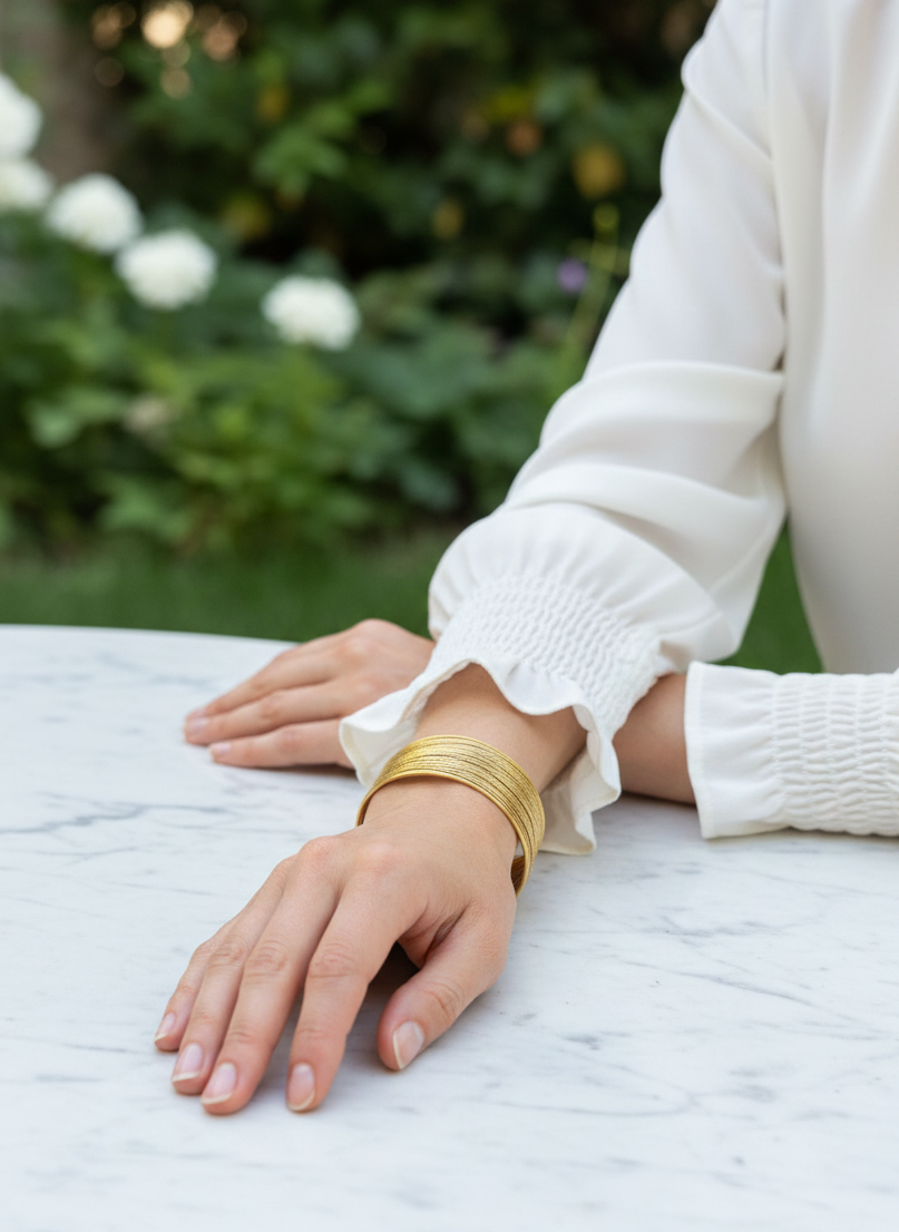 Brazalete de acero inoxidable ajustable. En color dorado.