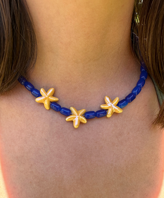 Collar hecho a mano con cuentas de cerámica en azul y tres estrellas de cerámica en amarillo en el centro. Con cierre ajustable en acero inoxidable 