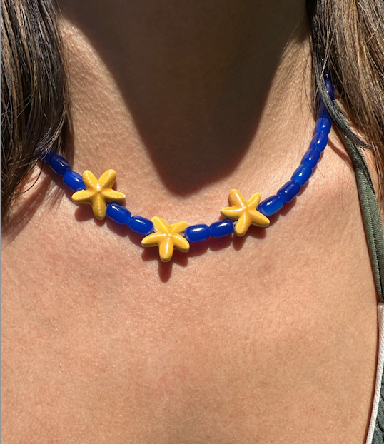 Collar hecho a mano con cuentas de cerámica en azul y tres estrellas de cerámica en amarillo en el centro. Con cierre ajustable en acero inoxidable 