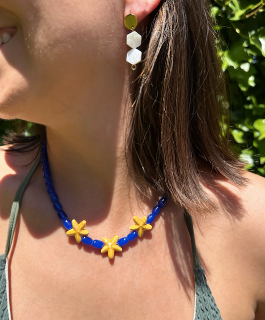 Collar hecho a mano con cuentas de cerámica en azul y tres estrellas de cerámica en amarillo en el centro. Con cierre ajustable en acero inoxidable 