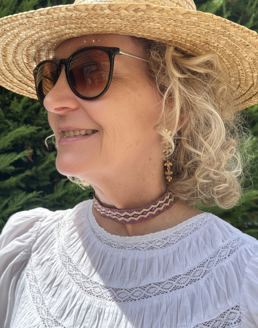 Modelo con choker de tela morado y dorado con dibujo étnico y cierre de acero inoxidable ajustable.