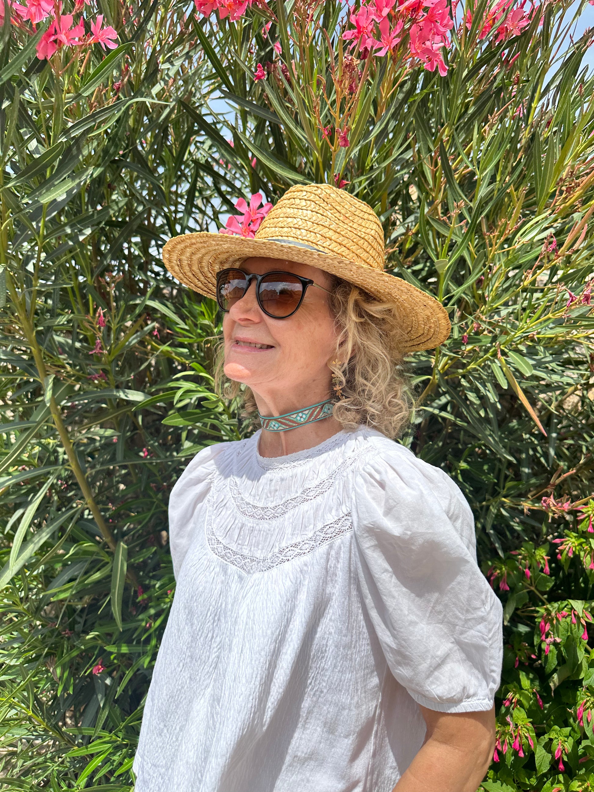 Modelo con choker de tela con patrón étnico en tonos turquesa y marrón con detalles dorados, cierre de acero inoxidable.