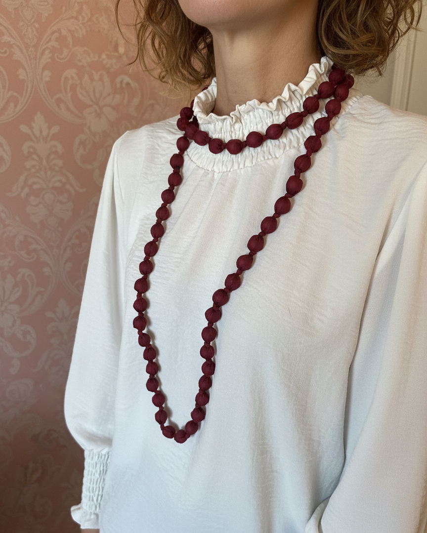Collar largo con cuentas de madera forrado con seda de color burdeos, muy especial, con posibilidad de dar varias vueltas. ¡No pesa nada!