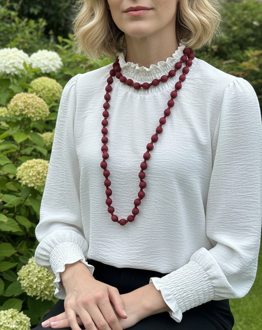 Collar largo con cuentas de madera forrado con seda de color burdeos, muy especial, con posibilidad de dar varias vueltas. ¡No pesa nada!