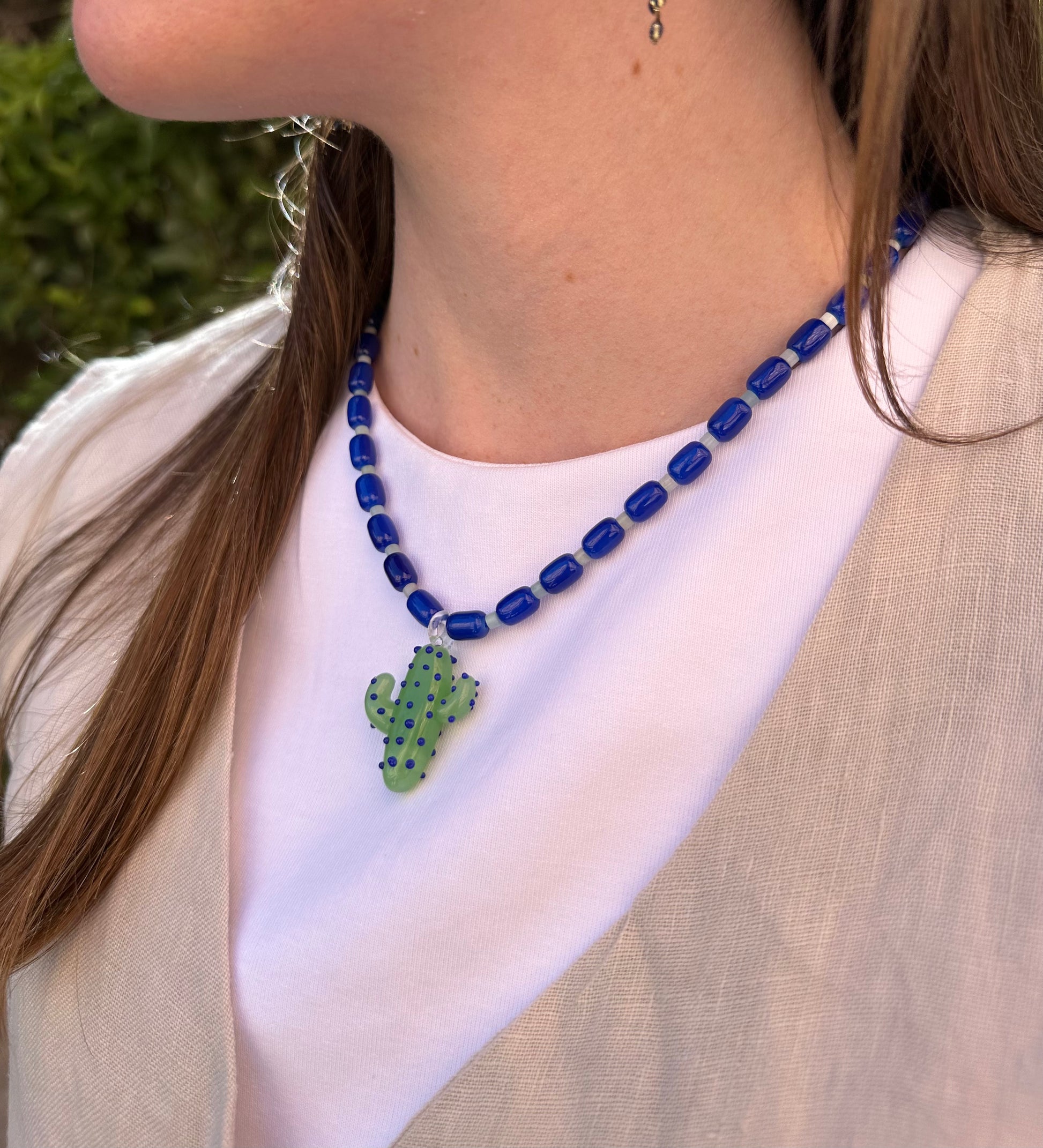 Collar hecho a mano con cuentas de cerámica azul y piedra agata de arbol con un abalorio con forma de cactus de cristal de murano en tono verde con puntos azules