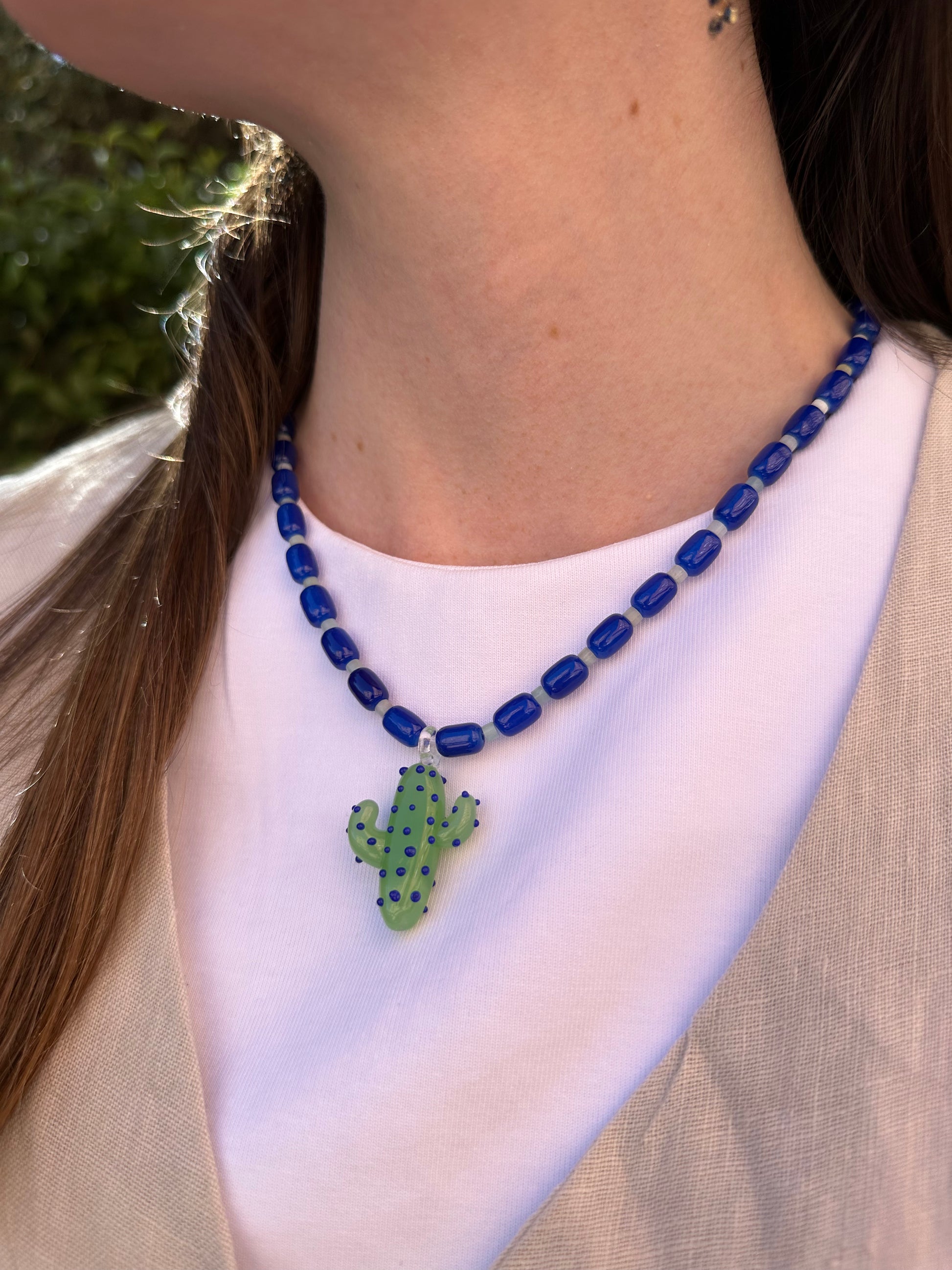 Collar hecho a mano con cuentas de cerámica azul y piedra agata de arbol con un abalorio con forma de cactus de cristal de murano en tono verde con puntos azules