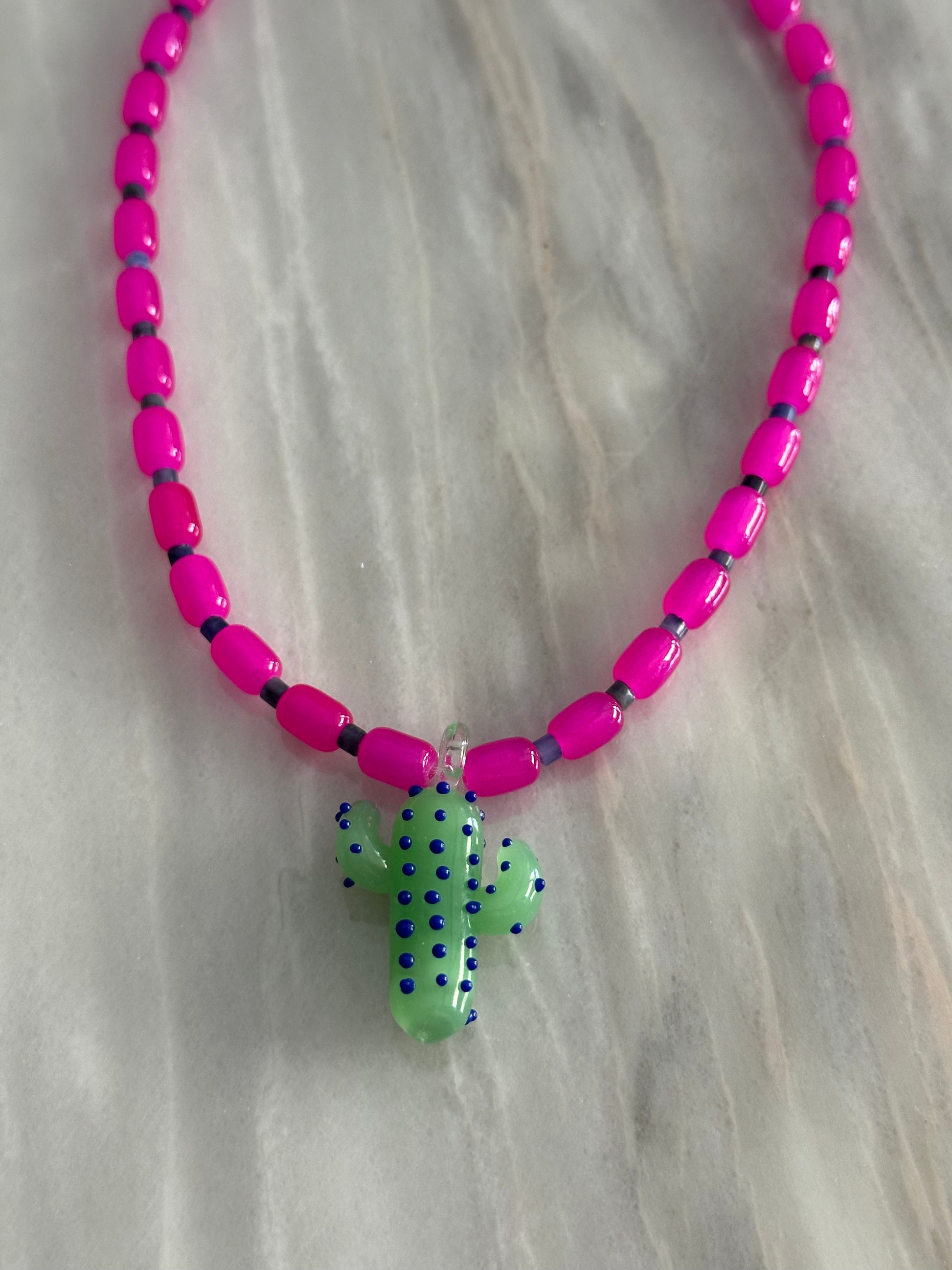 Collar hecho a mano con cuentas de cerámica rosa y piedra sodalita (Azul), con un abalorio con forma de cactus de cristal de murano en tono verde con puntos azules